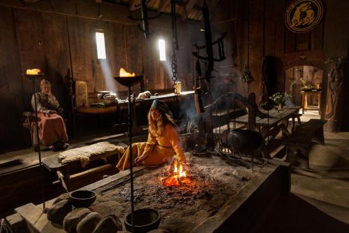Historical interpreters bring a reconstructed longhouse to life at the Ribe Viking Center in Denmark. Meals were cooked over an open fire on a hearth, and Viking fare included salted herring, barley porridge, and boiled sheep heads.  PHOTOGRAPH BY DAVID GUTTENFELDER, NATIONAL GEOGRAPHIC